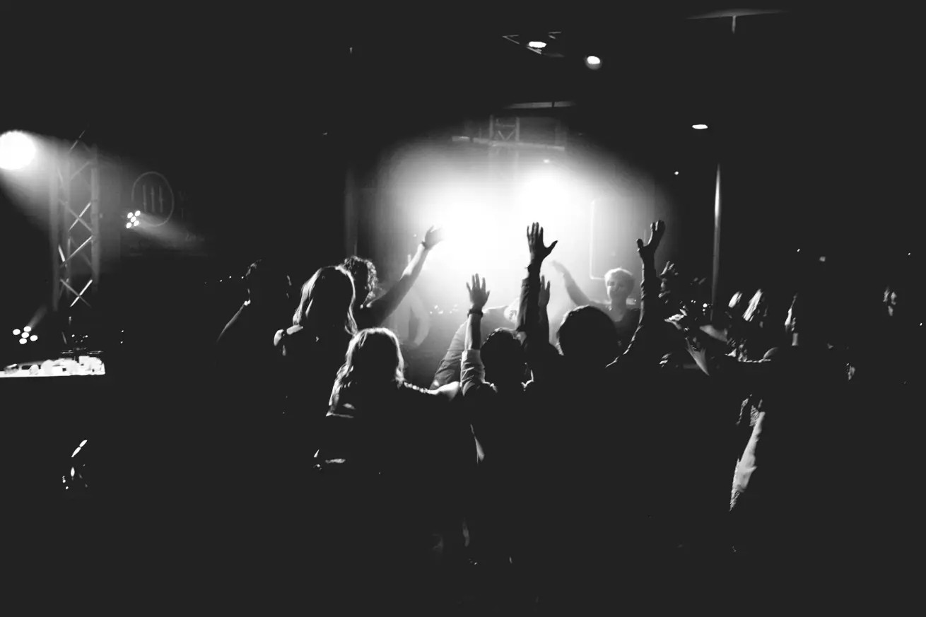 Jubelndes Publikum in einer kleinen Konzert-Location im Gegenlicht.